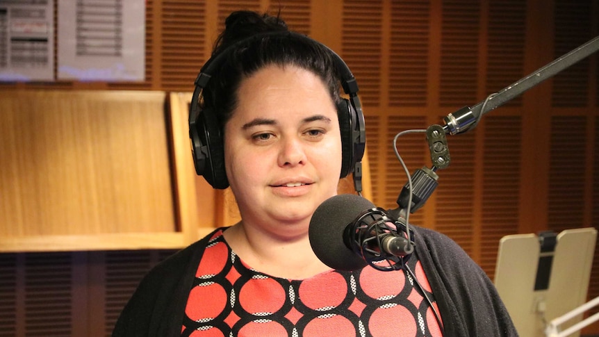 Bremer in radio studio talking into microphone.