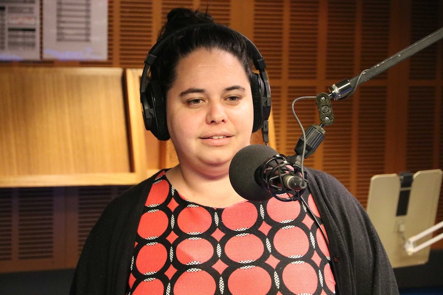 Bremer in radio studio talking into microphone.