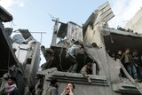 Palestinians survey scene of Israeli air strike on the home of senior Hamas leader Nizar Rayyan