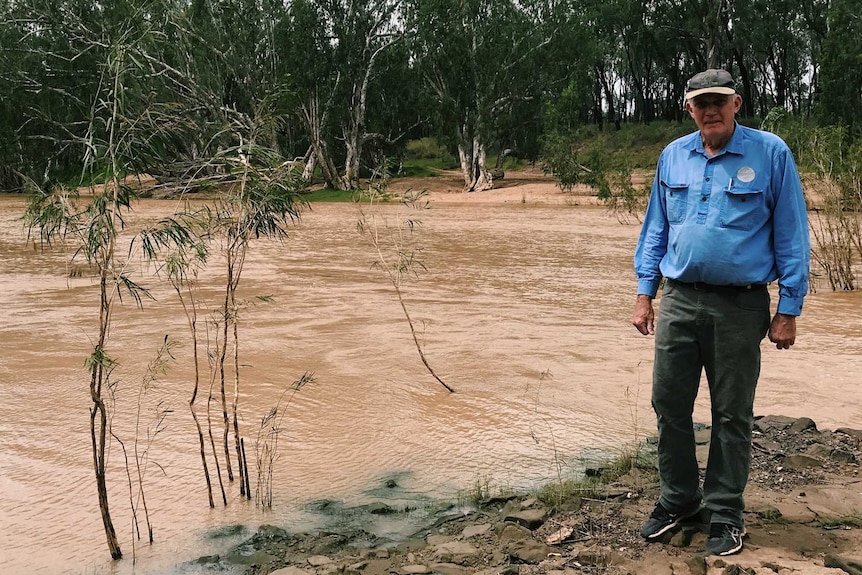 man standing next to river