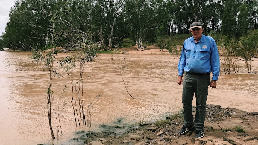 man standing next to river