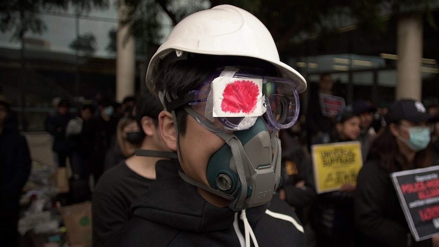 A pro-Hong Kong demonstrator wears a helmet and mask at an Adelaide rally.
