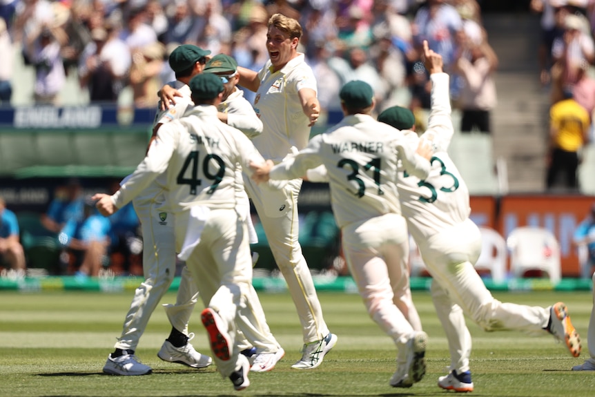 Australian Test cricketers run to celebrate with a jumping Cameron Green after winning the third Ashes Test at the MCG.