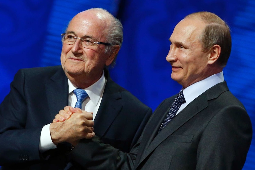 Sepp Blatter shakes hands with Vladimir Putin in Russia on Saturday, July 25