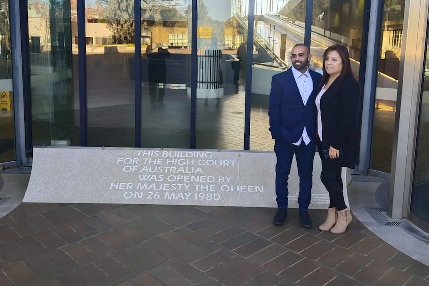 A couple stands outside the high court with hopeful smiles on their faces.