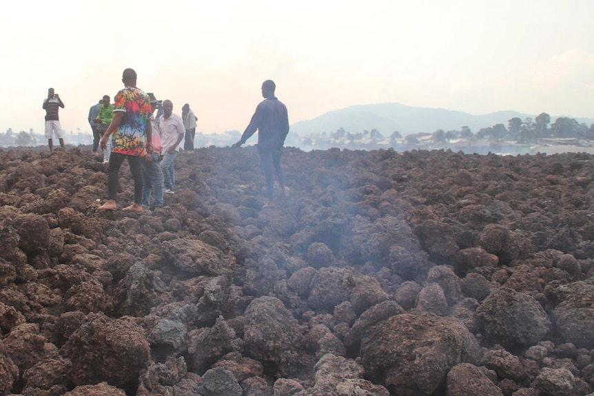 People walk over lava rocks in Congo