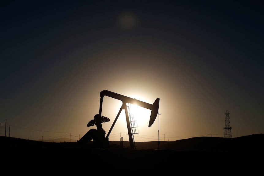 An oil well pump jack is seen at sunrise near Bakersfield, California
