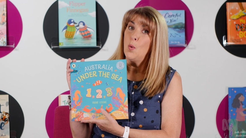 Teacher Karen Palowicz holds up story book, Australia Under the Sea 1, 2, 3