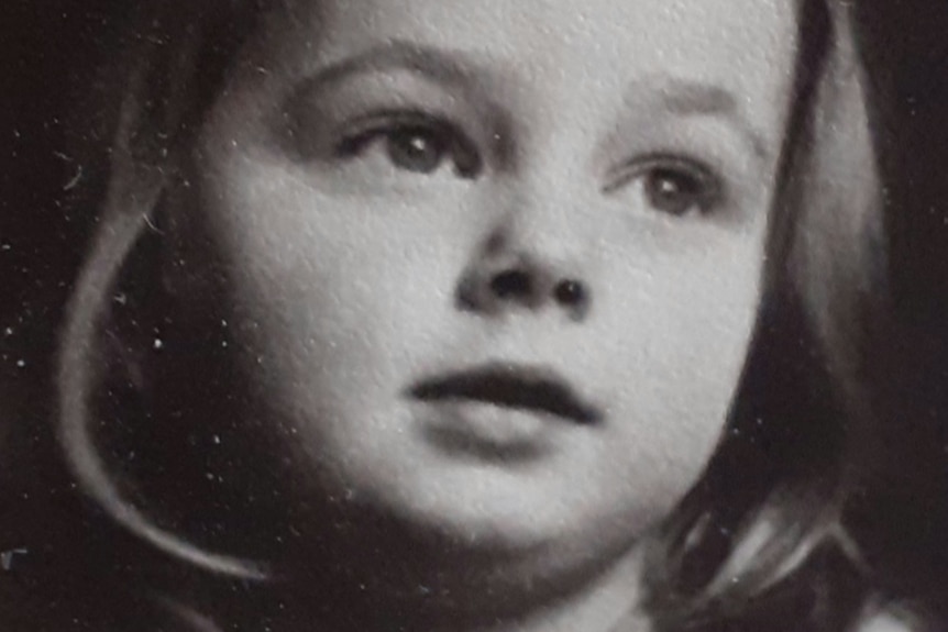A black and white photograph of pianist Penelope Thwaites as a young girl with a ribbon in her hair.
