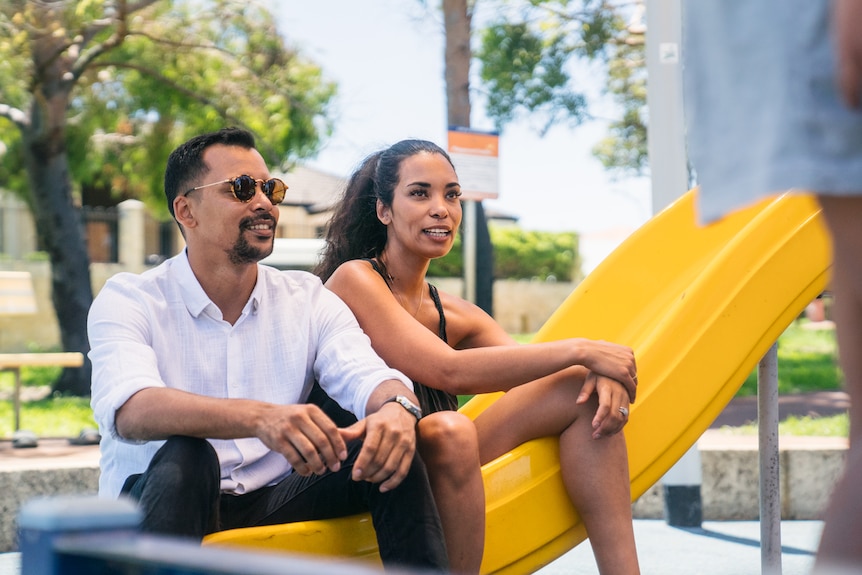 Siblings Mirwan Carollisen and Siham Benz sit at playground