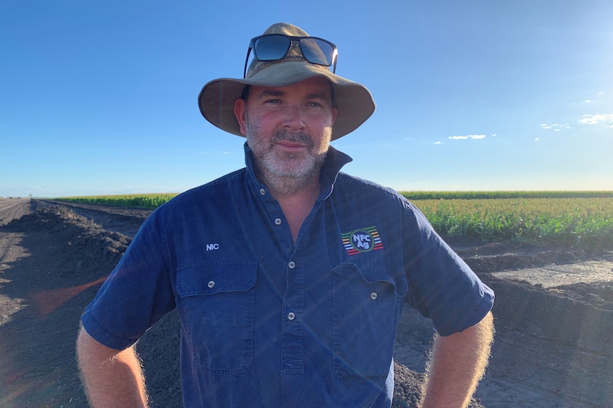 Photo of a man standing in front of a field.