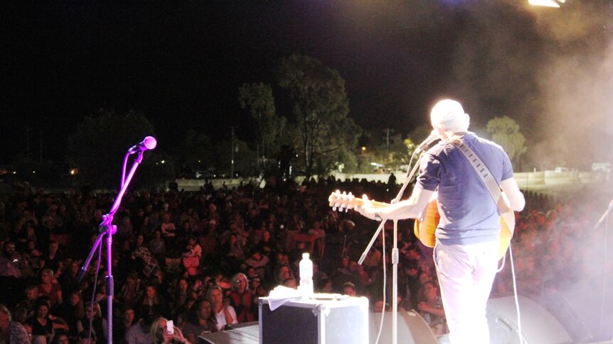 Paul Kelly performs in front of thousands of people at a drought relief concert in Longreach.