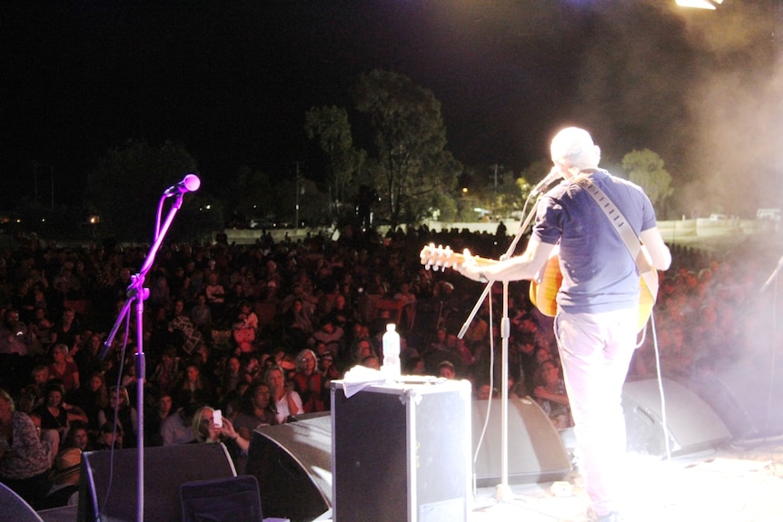 Paul Kelly performs in front of thousands of people at a drought relief concert in Longreach.