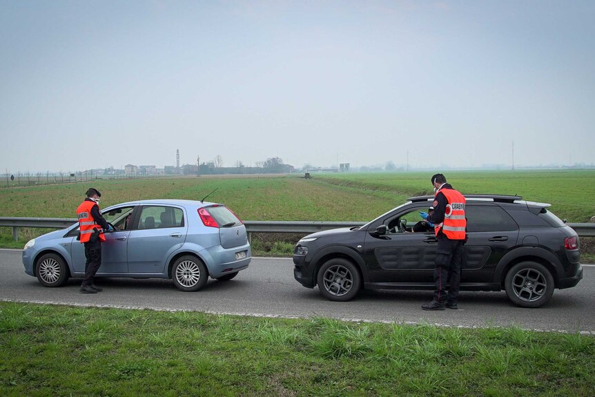 Police stop two vehicles on the outskirts of Codogna in northern Italy.