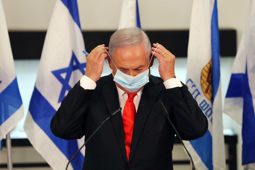 Benjamin Netanyahu putting on a face mask