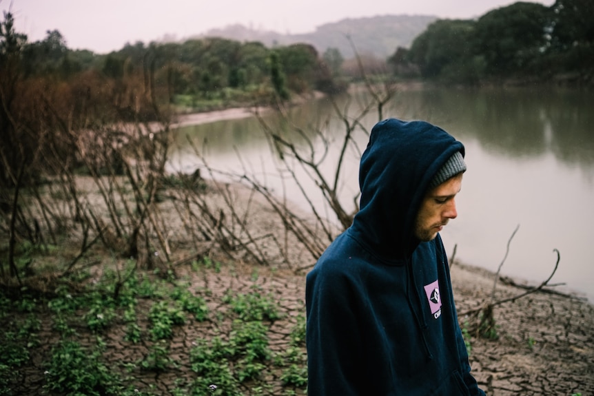 Man the bank of the now receded river that runs behind his house.