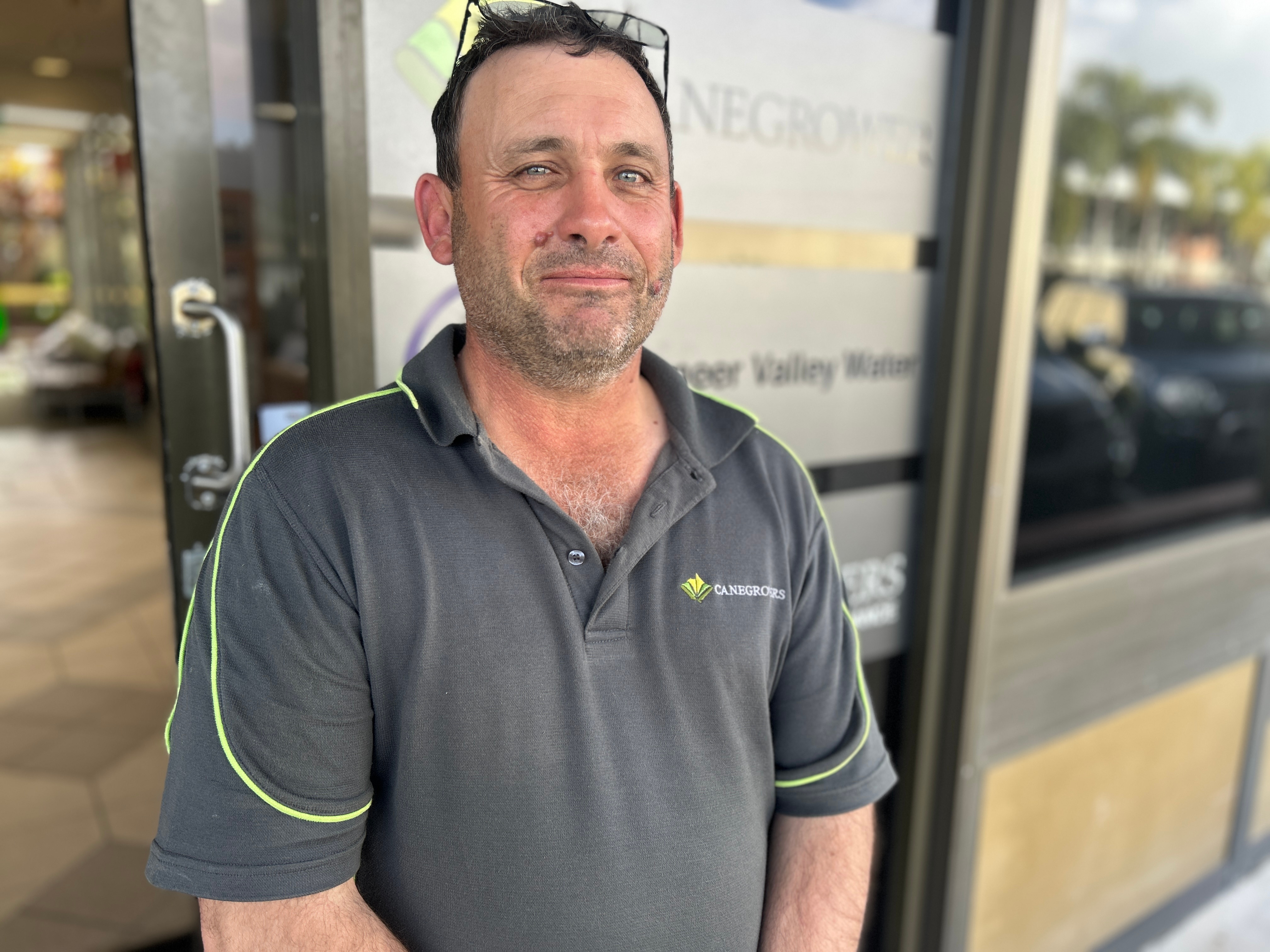 A man in a canegrowers shirt looking at the camera