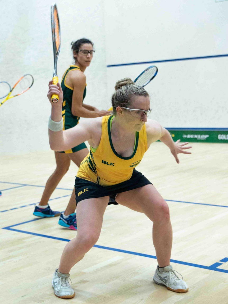 A woman prepares to hit a squash ball during a squash match.