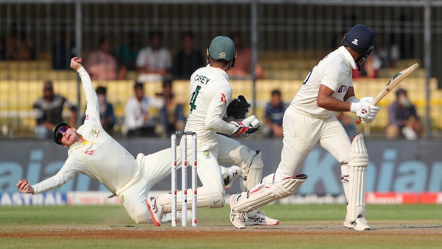 Australia fielder Steve Smith takes a one-handed catch as the rest of his body splays out, removing India's Cheteshwar Pujara.