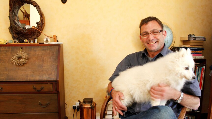 Walter Van Praag with his dog in his Devonport home