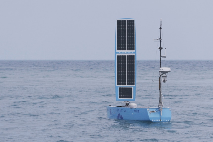 blue vessel in deep ocean with solar panel standing  up