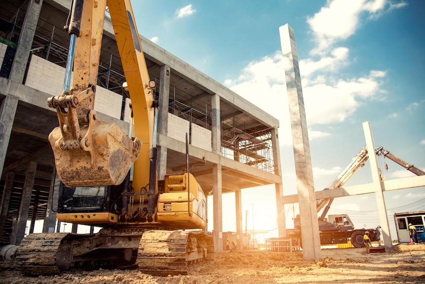 A bulldozer knocking down an apartment block