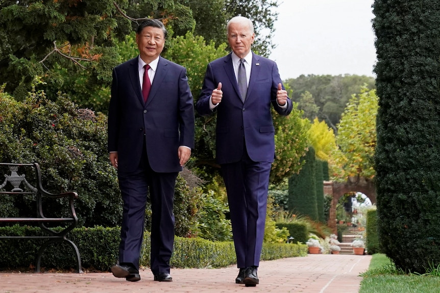 Two men in suits walk together.