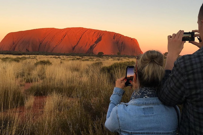 People taking photos of Uluru
