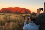 People taking photos of Uluru