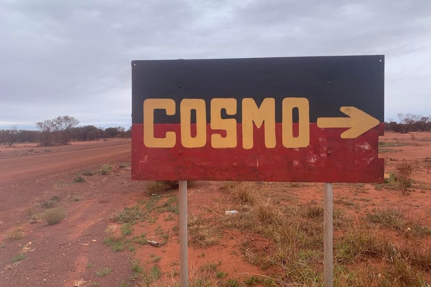 The town sign is like the Aboriginal flag, but the yellow centre spells 'Cosmo'.