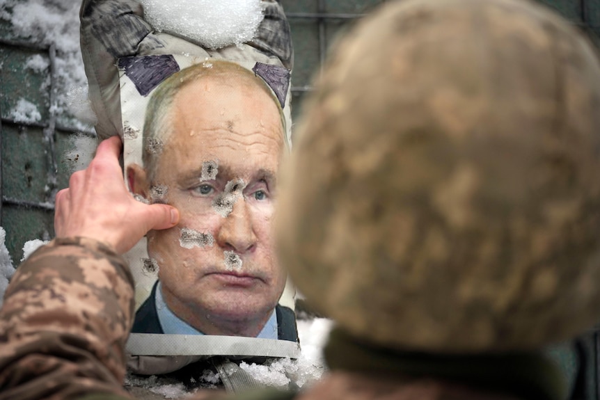 A Ukrainian serviceman adjusts a bullet riddled effigy of Russian President Vladimir Putin.