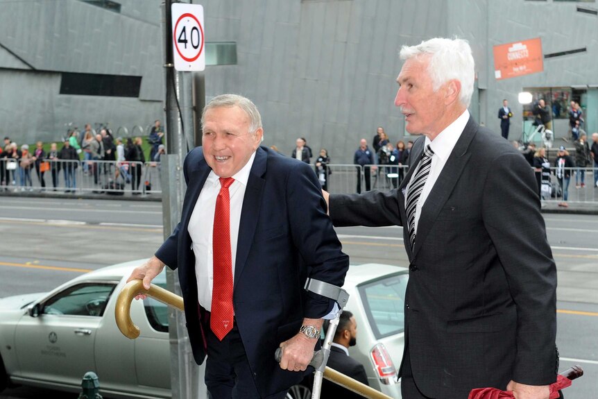Mick Malthouse (R) helps Bob Skilton up the stairs of St Paul's Cathedral.