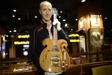 Auction director holds Vox guitar played by Bealtes