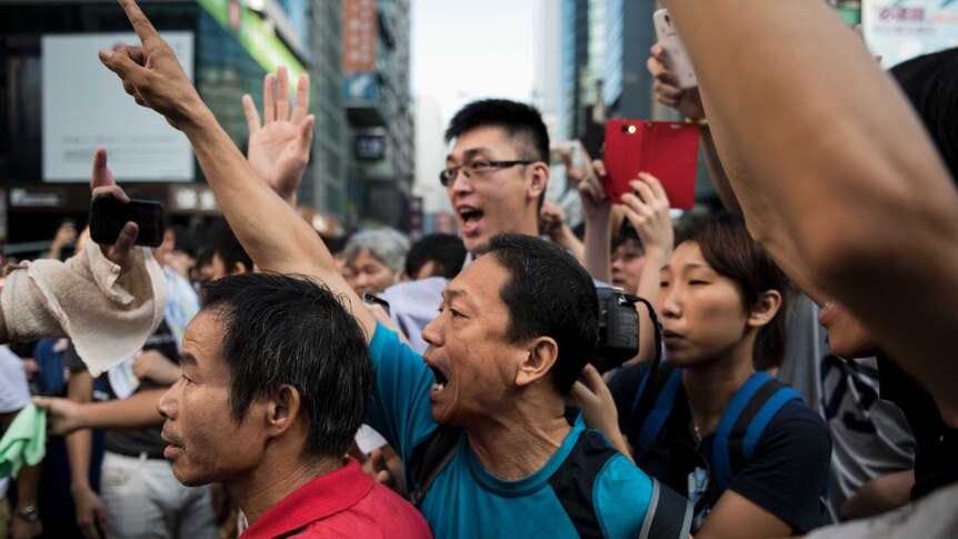 Pro-democracy protesters shout at a man (unseen) opposing their occupation of Nathan Road
