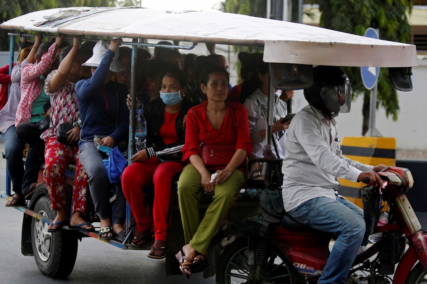 A group of women sit on a covered vehicle.