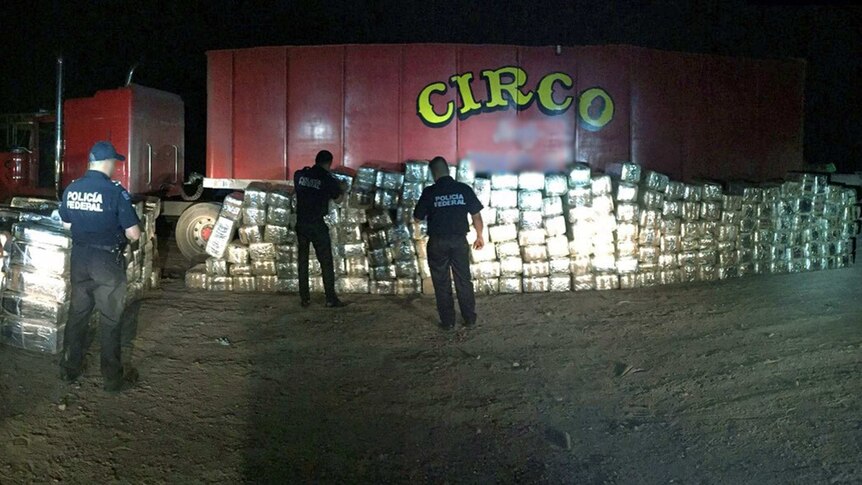 Mexican Federal Police officers stand next to four tons of marijuana