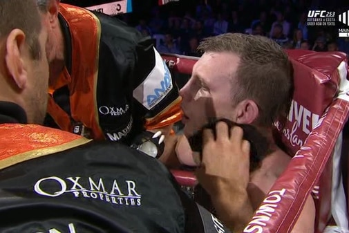 Jeff Horn sits slumped in his chair in the corner of a boxing ring with people around him