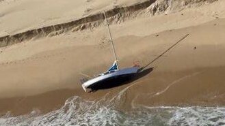 A small yacht ot its side on the beach
