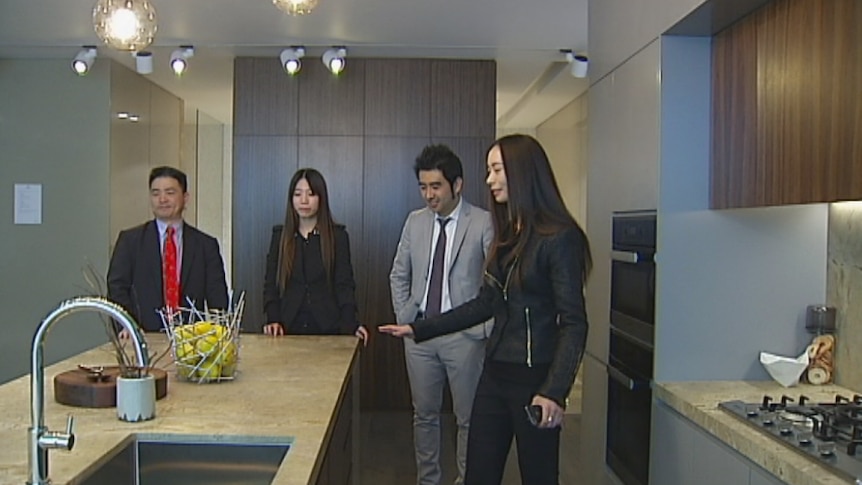 Prospective buyers look at apartment display suite