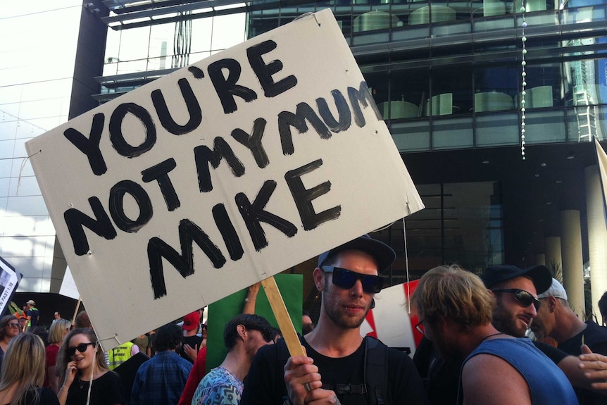 A protester holds a sign that reads "You're not my Mum, Mike" at a march against lockout laws in Sydney.