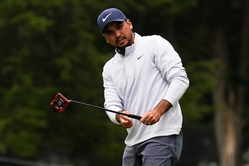 Jason Day holds his putter up and grimaces as he looks at a putt during the PGA Championship.