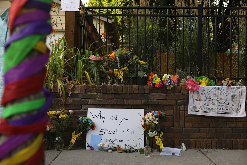 A memorial for Justine Damond with a sign reading "why did you shoot and kill our friend?"