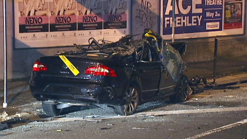 One of two cars that fell from a truck when the driver misjudged the height of a suburban bridge.