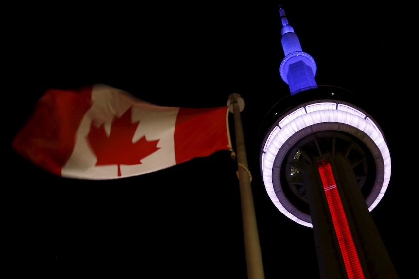 Landmark CN Tower in Toronto lit up in blue, white and red