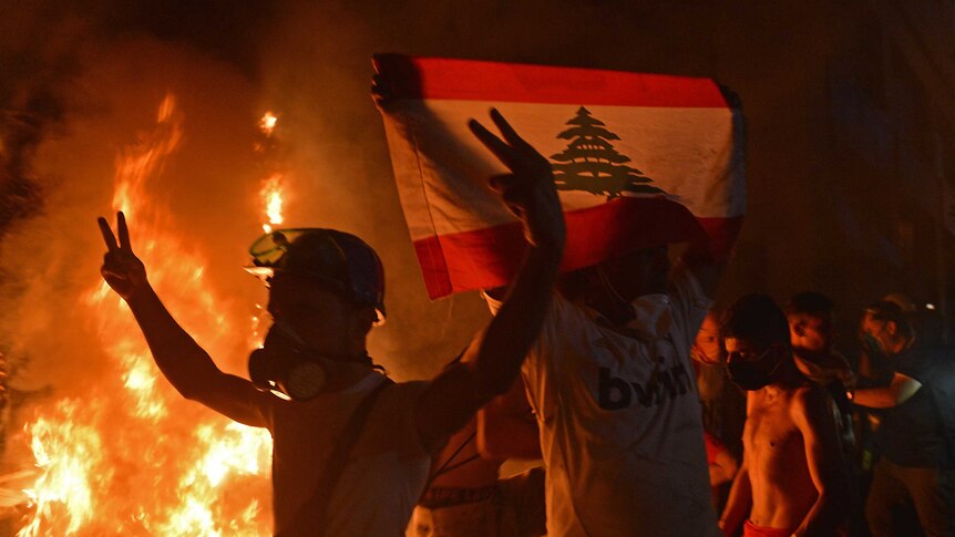 Lebanese demonstrators try to break through a barrier following the resignation of the government.