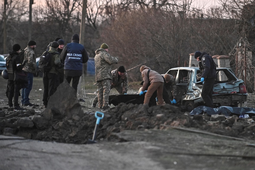 People surrounding an explosion site after missile strikes.