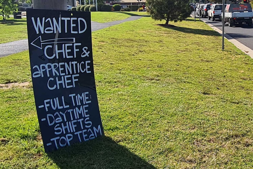 A sign sits by a busy road in Bendigo advertising a chef position and apprentice chef position