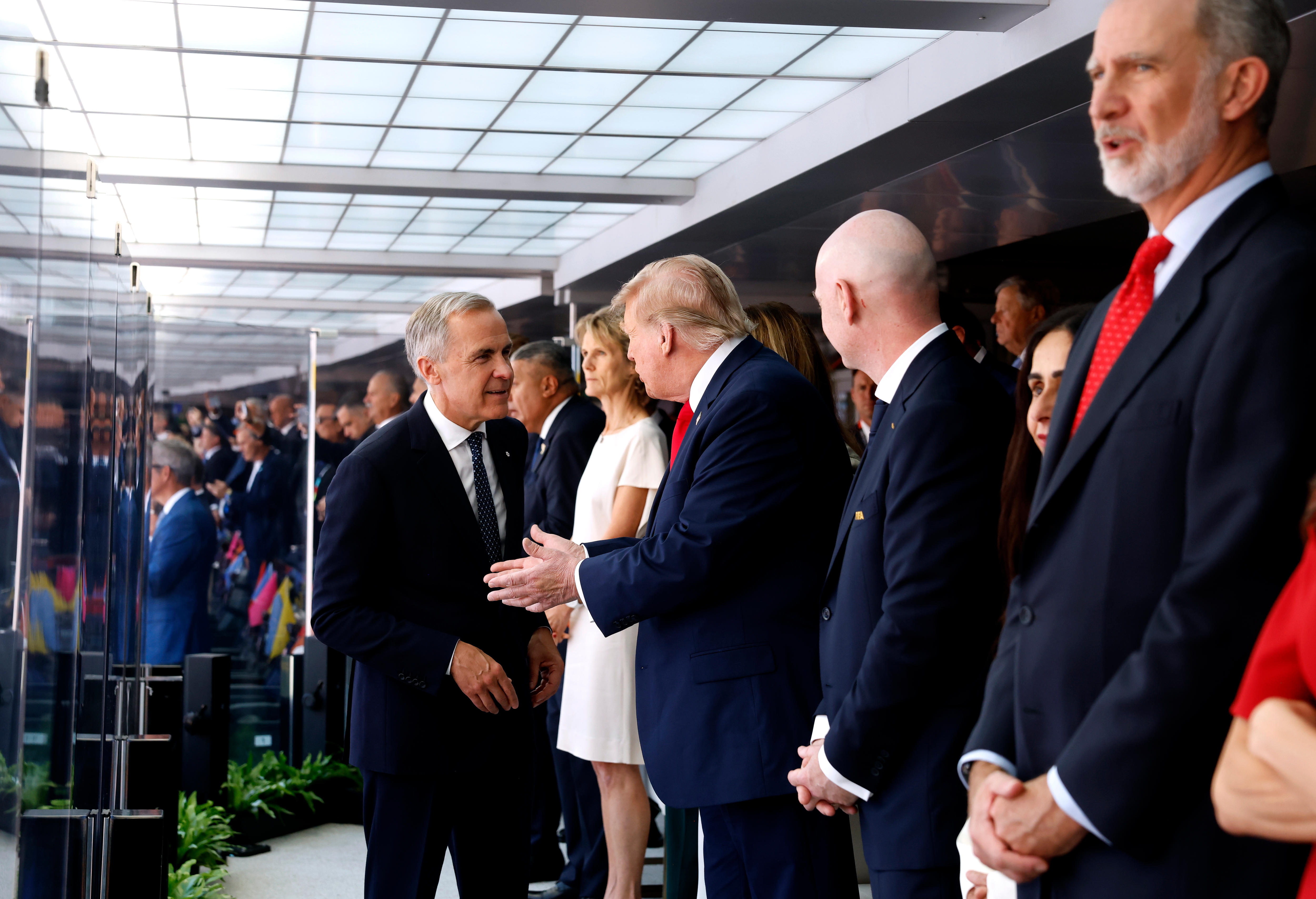 Men in suits shake hands.