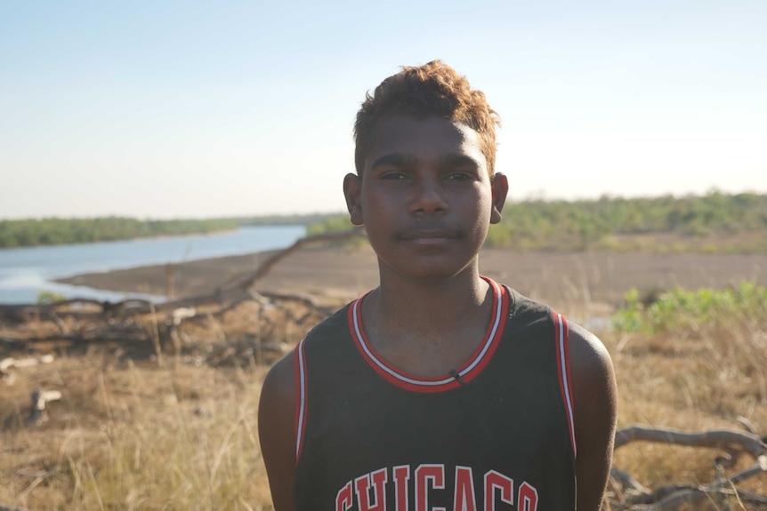 Jedakai Johnson is standing on the bank of the Robinson River on Seven Emu Station