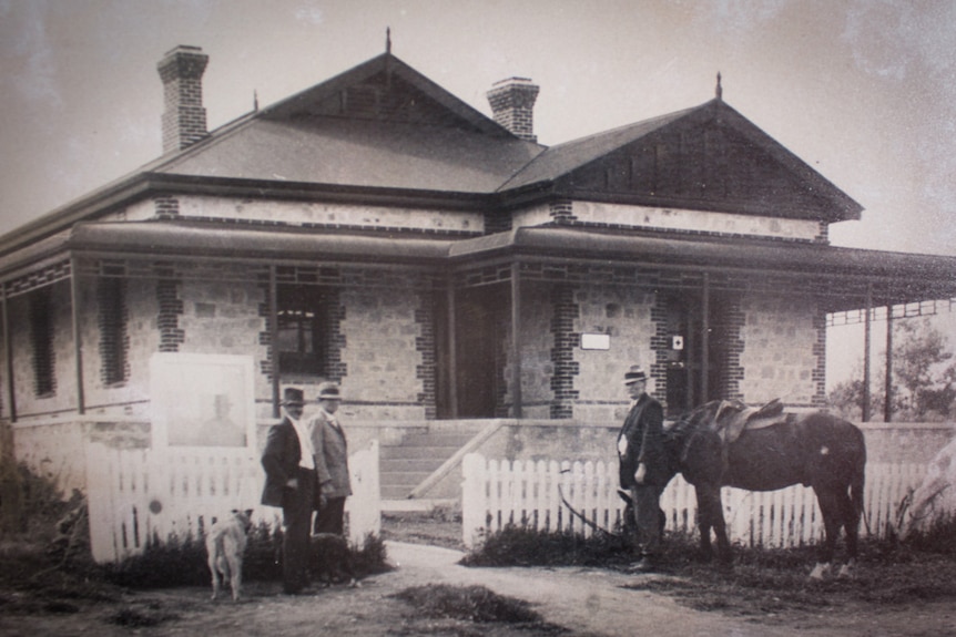 An old photo of the art gallery with men and a horse at the front of the building.